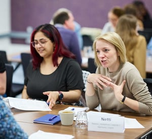 A woman talking to a group of people at a workshop