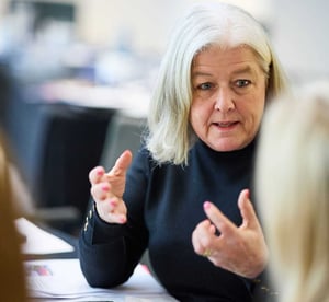 A woman in talking to a fellow attendee at a management development programme