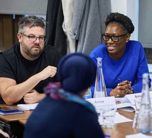 Two colleagues deep in conversation at a team workshop