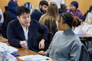 A diverse team collaborates in a meeting, building resilience through strengths-based leadership.  