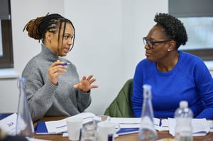 A manager having a one-on-one conversation with a team member, fostering open communication and understanding strengths.