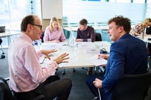 A manager facilitating a strengths-based conflict resolution discussion in a diverse workplace setting.