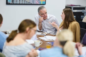 A collaborative team discussion showcasing engaged employees, fostering strengths-based productivity and reducing burnout.