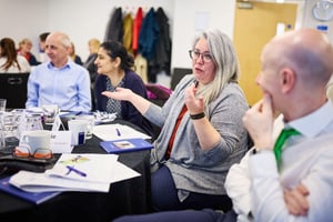 Team members engaged in open, honest dialogue during a strengths-based away day session.