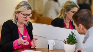 Two colleagues discussing strengths and opportunities during a performance review in a collaborative office setting.